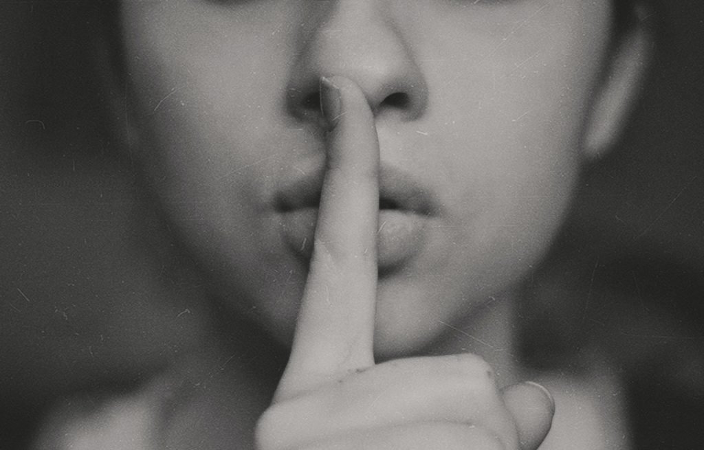 Close-up of person shushing with finger