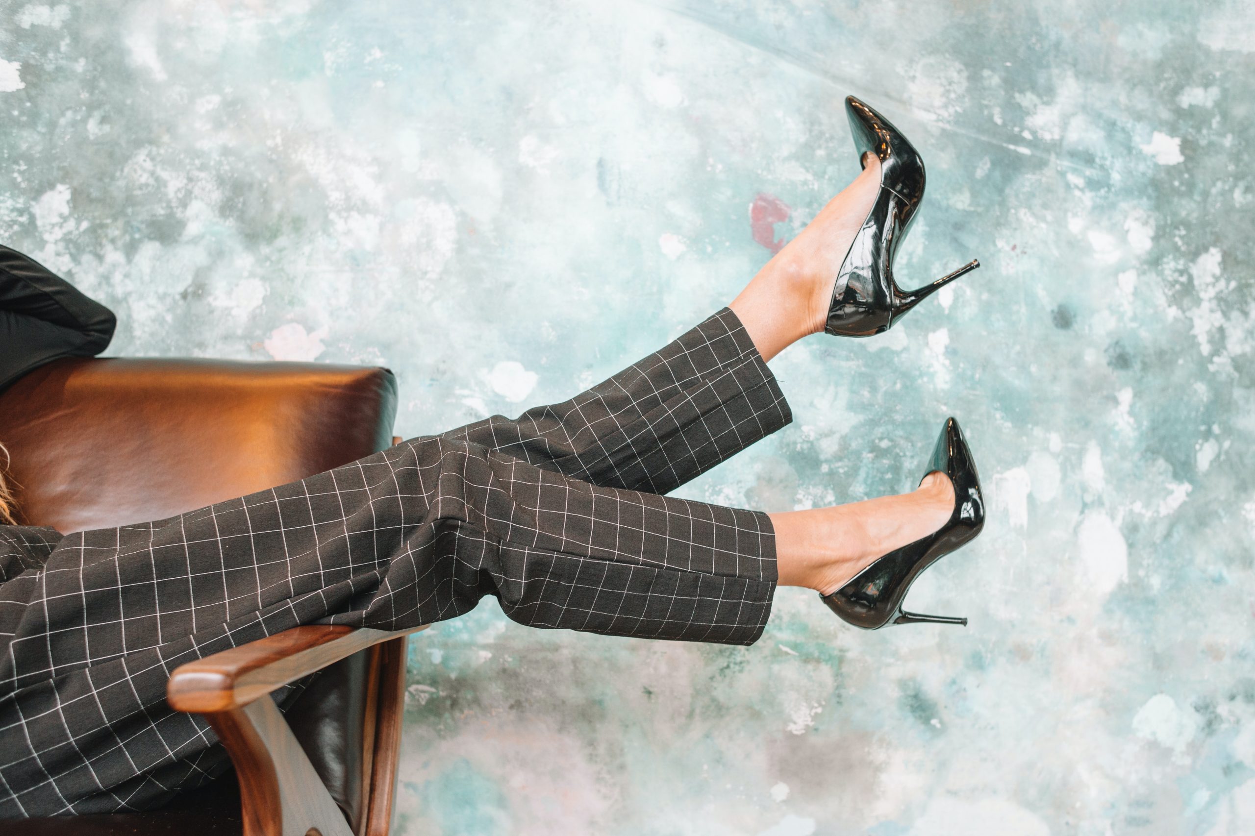 Legs wearing plaid trousers and black high heels