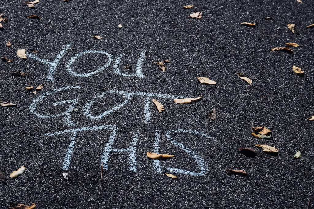 Chalk writing "You got this" on asphalt