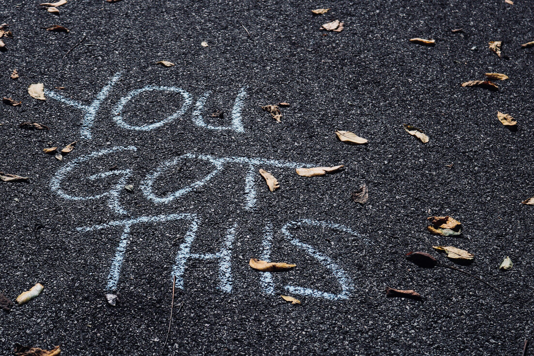 Chalk writing "You got this" on asphalt