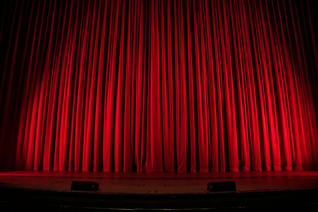 Closed red theater curtains on stage