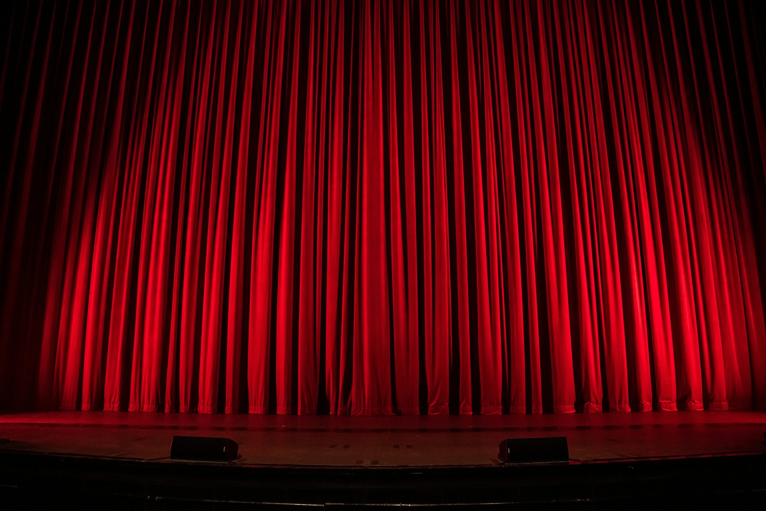 Closed red theater curtains on stage