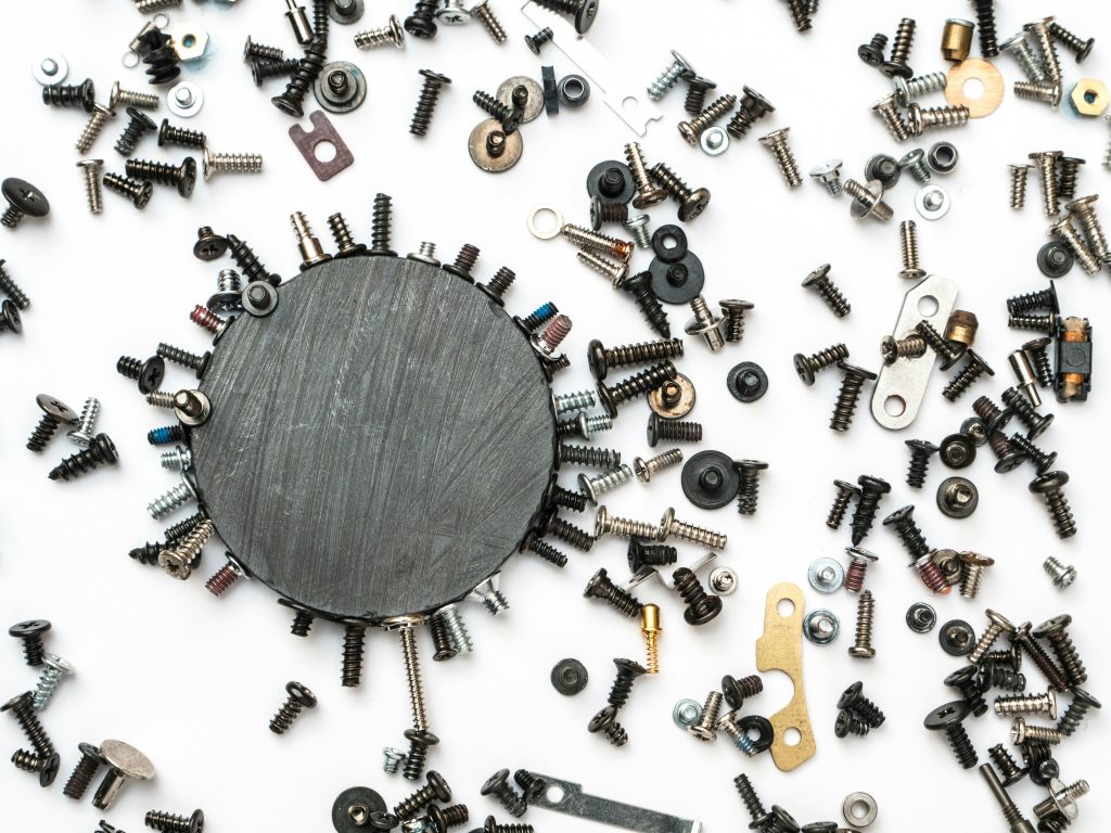 Round magnet with scattered screws and fasteners