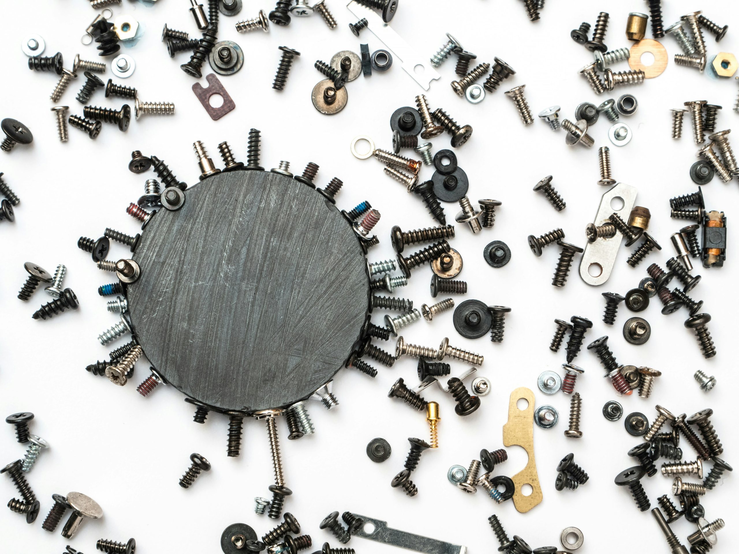 Round magnet with scattered screws and fasteners