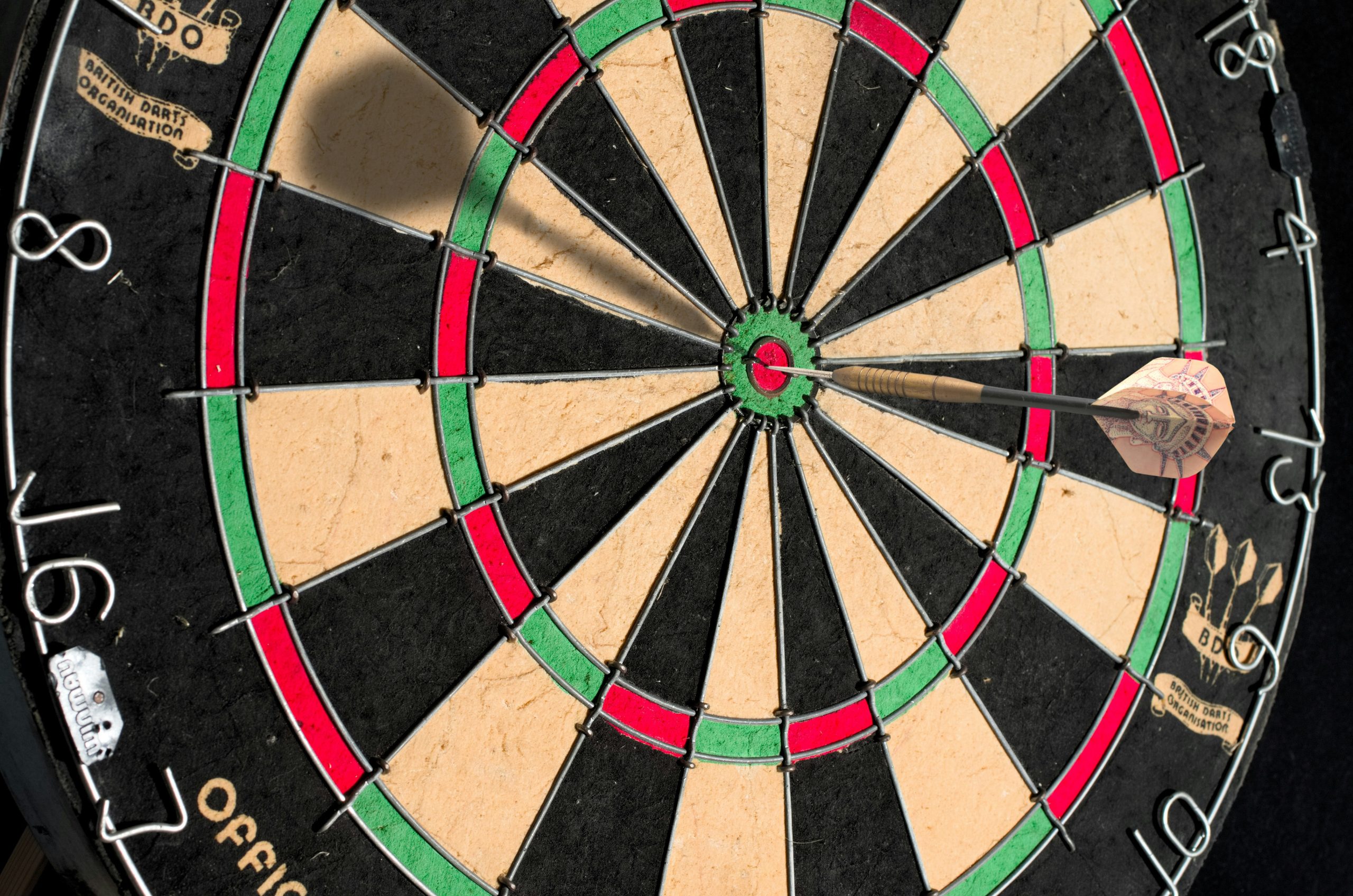 Dartboard with darts near the bullseye
